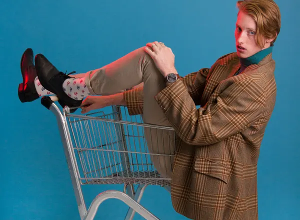 man in brown jacket sitting in shopping cart