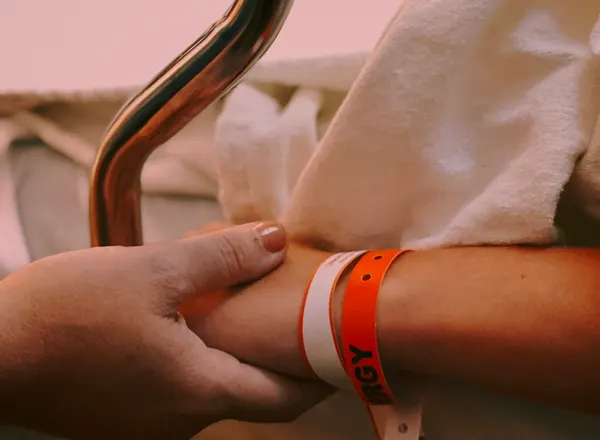 person wearing orange and white silicone band